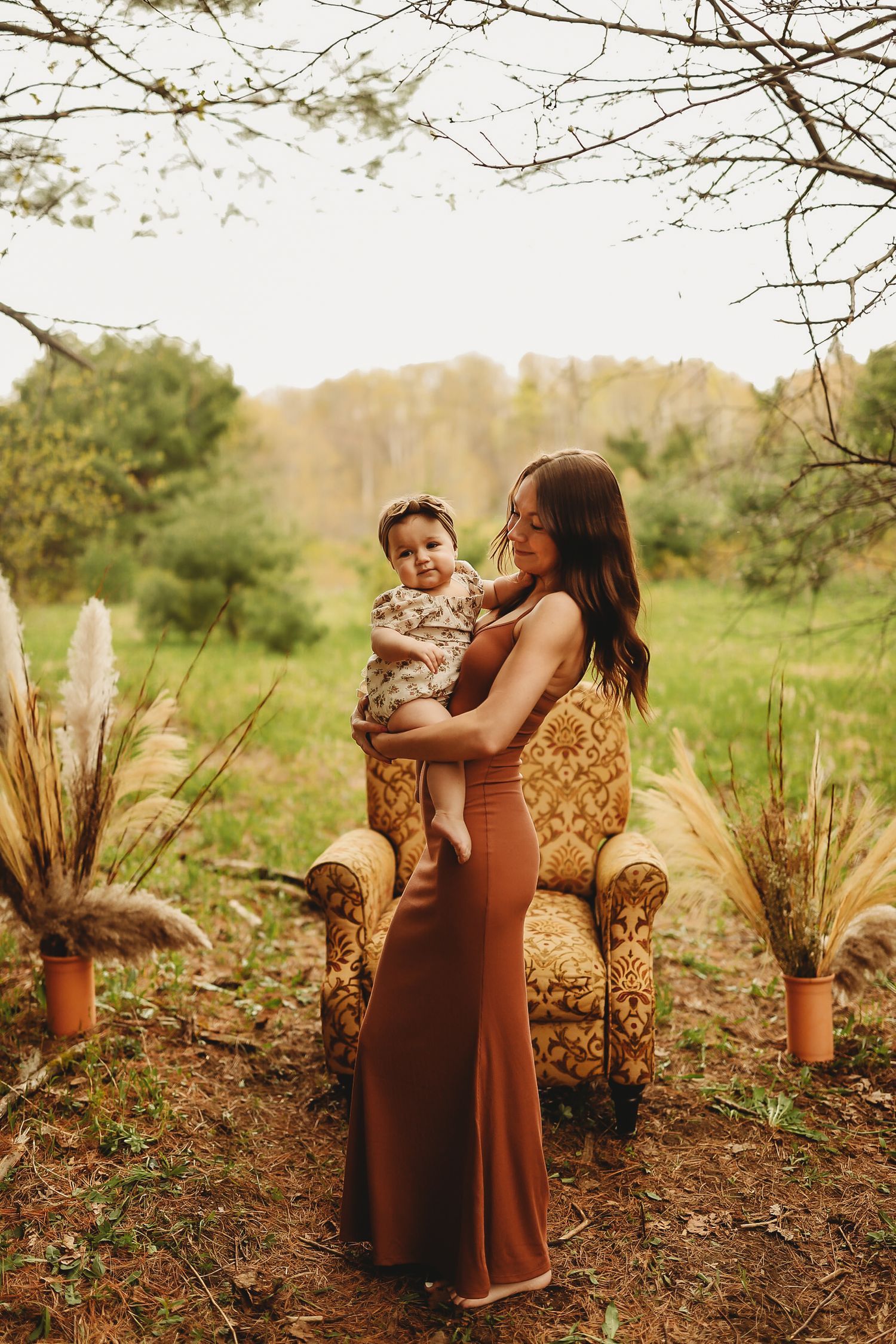 A tender moment captured outdoors with a vintage armchair and pampas grass decoration.