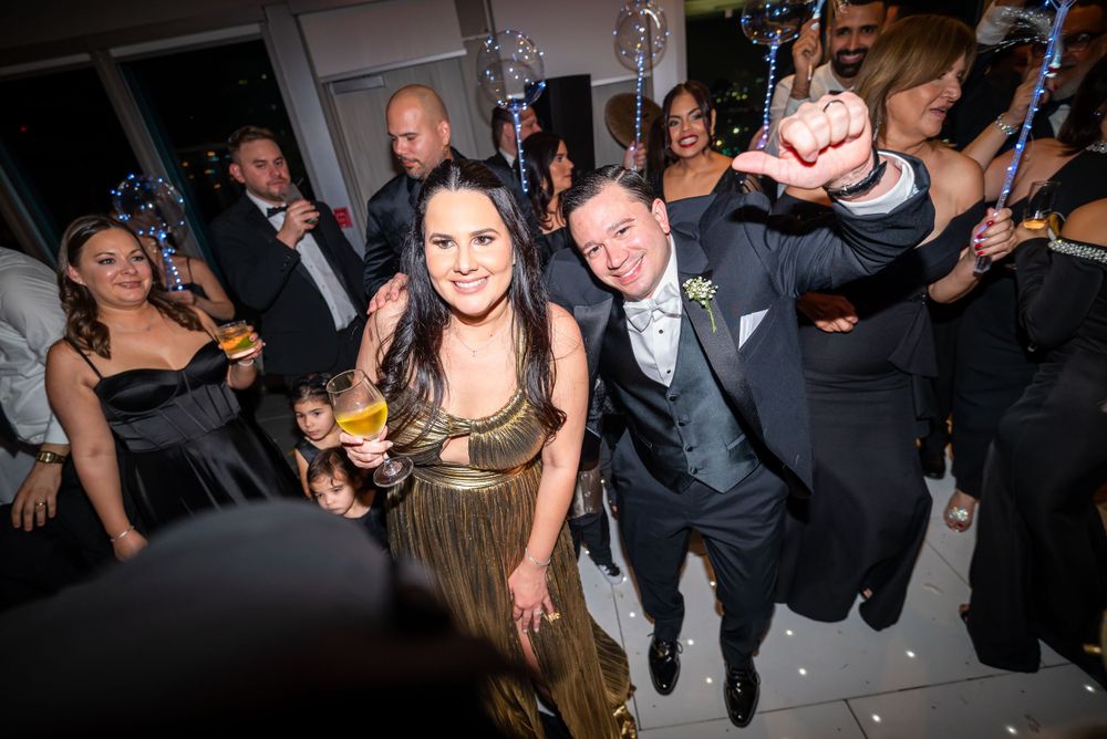 Wedding celebration with guests dancing and having fun in formal attire at an elegant venue.