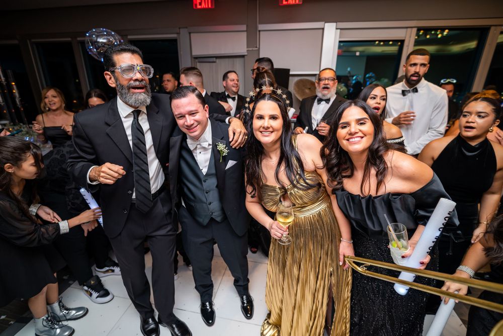 Lively wedding reception with guests celebrating and dancing in formal attire.