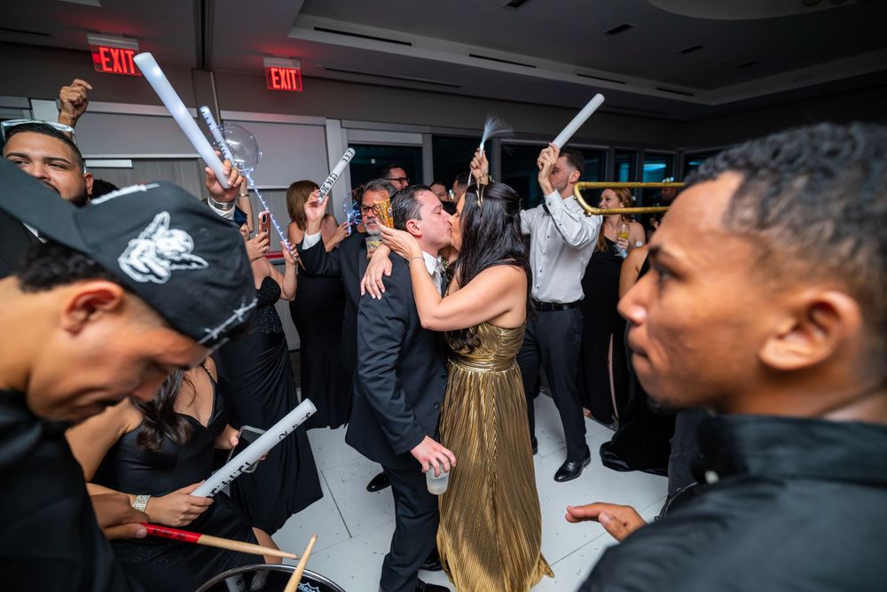 Wedding guests celebrating with light-up batons on a dance floor during reception party.