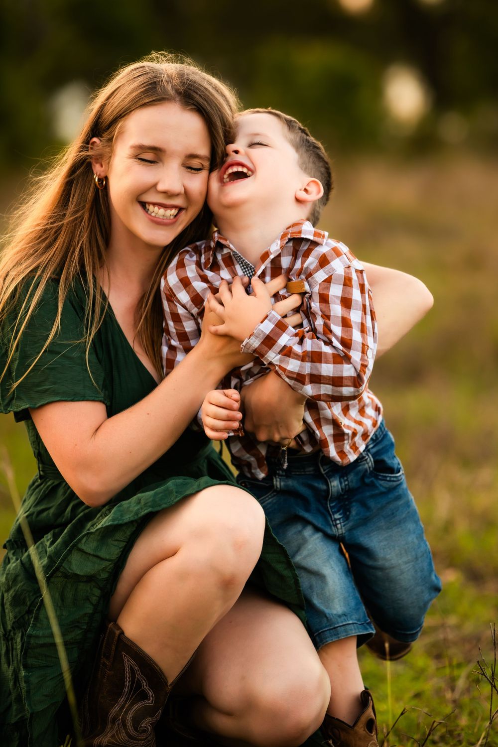 Joyful laughing together in a casual outdoor portrait wearing green dress and plaid shirt.
