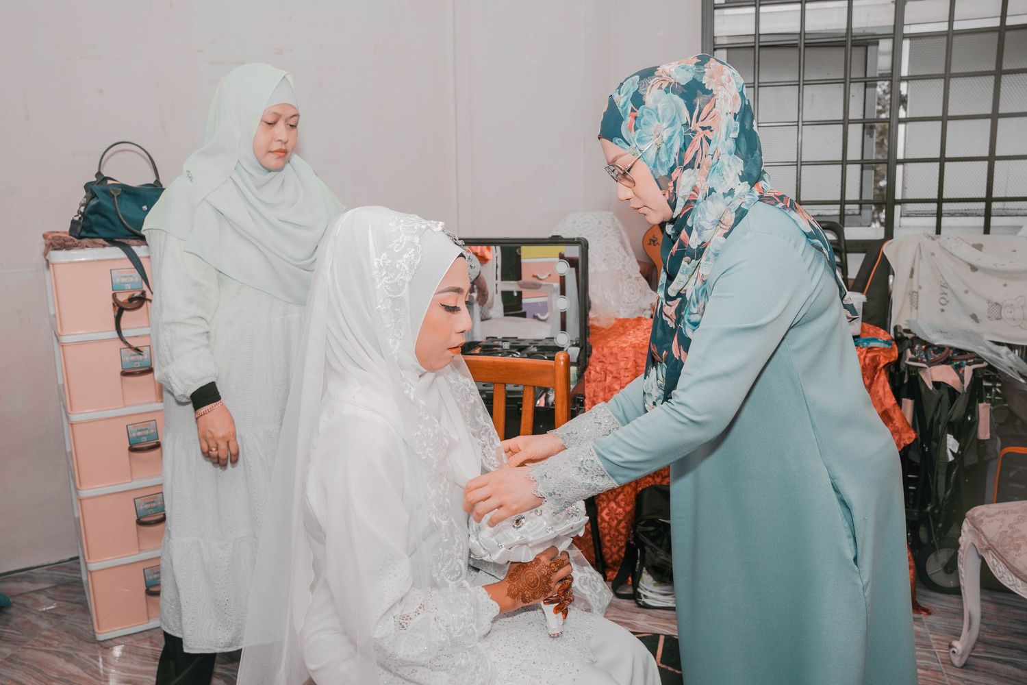 Women in traditional dress preparing a bride for her wedding ceremony.