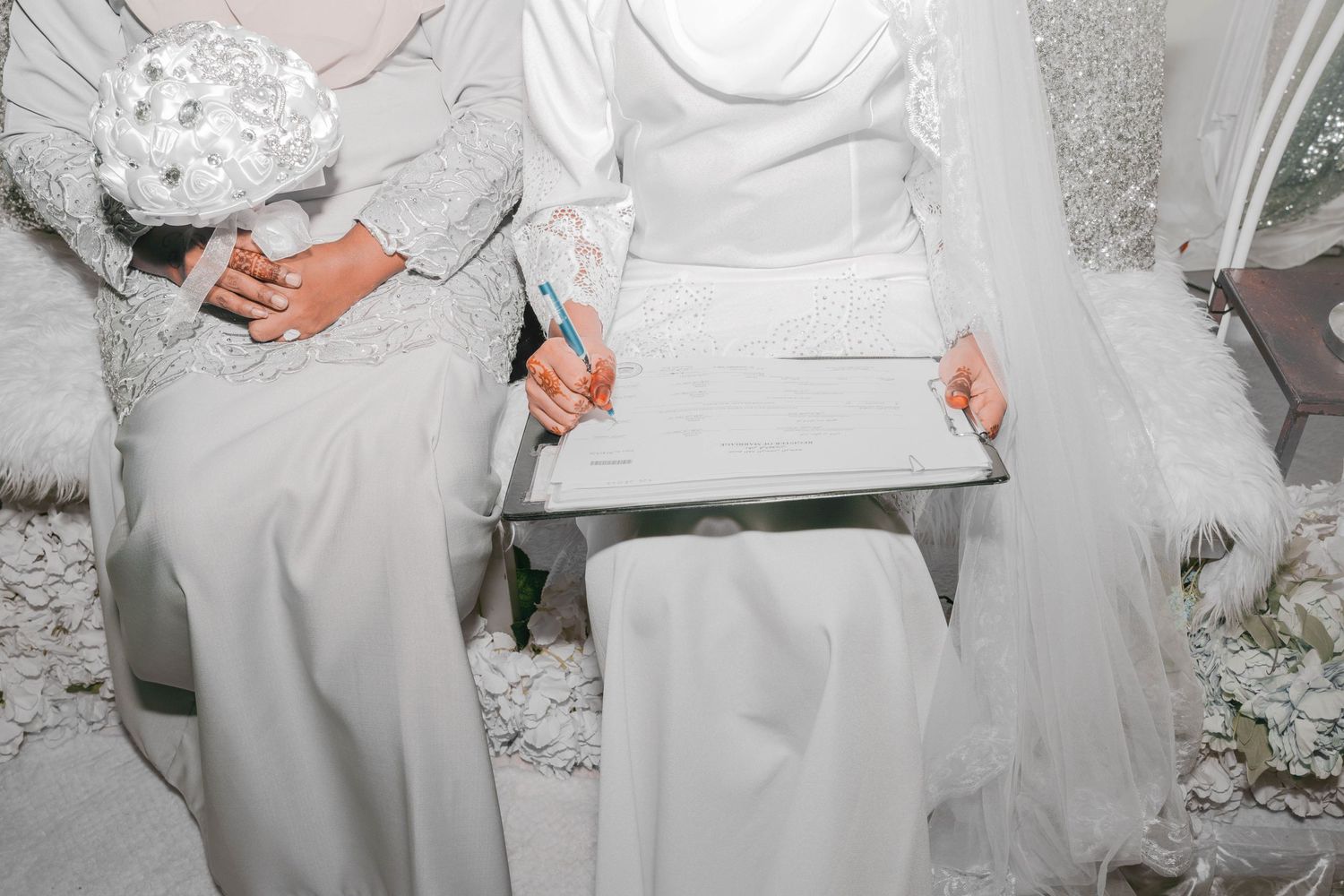 Close-up of hands holding documents during a traditional wedding ceremony.