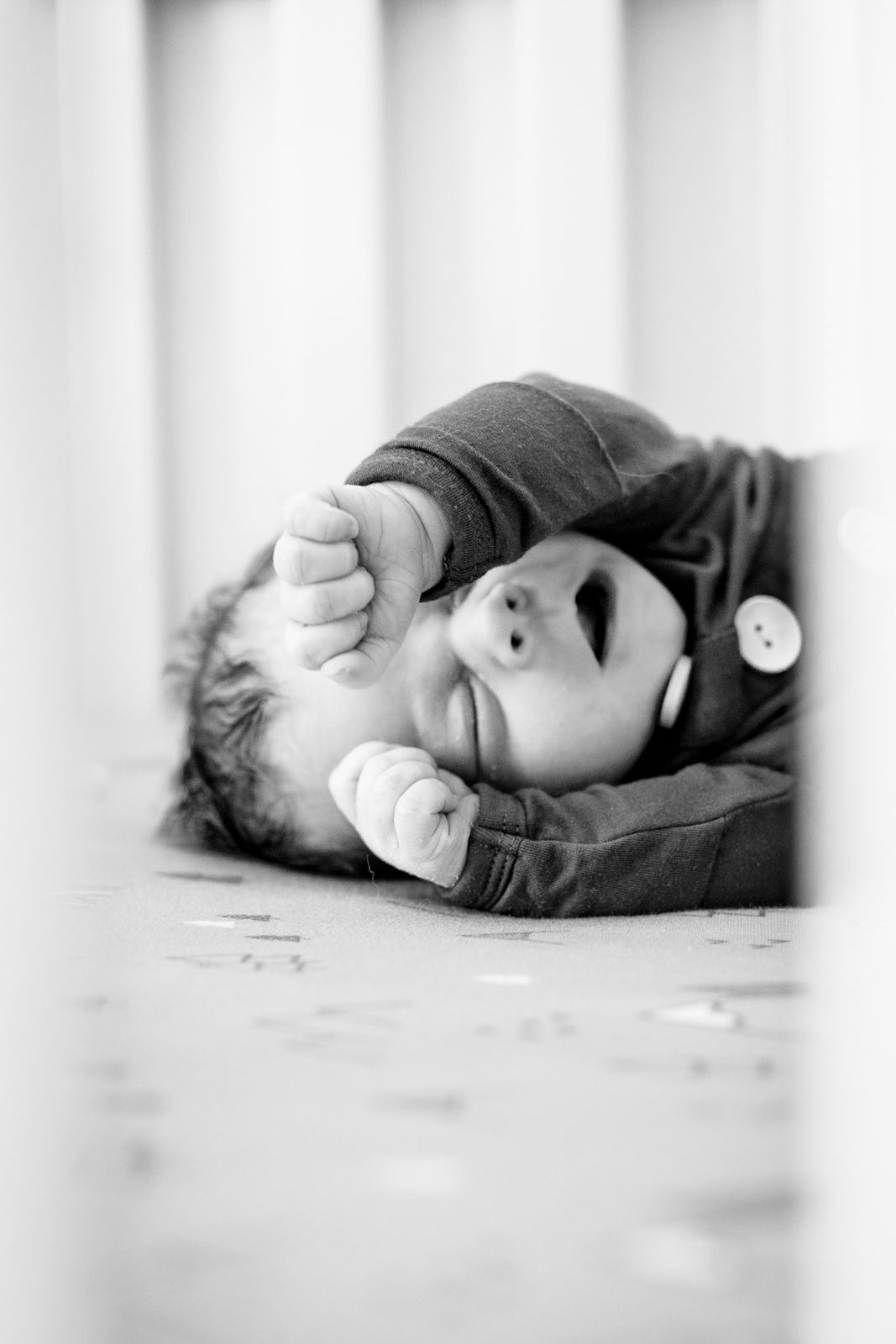 Beautiful lifestyle newborn photography; black and white; baby yawning in crib; Clarissa Anello
