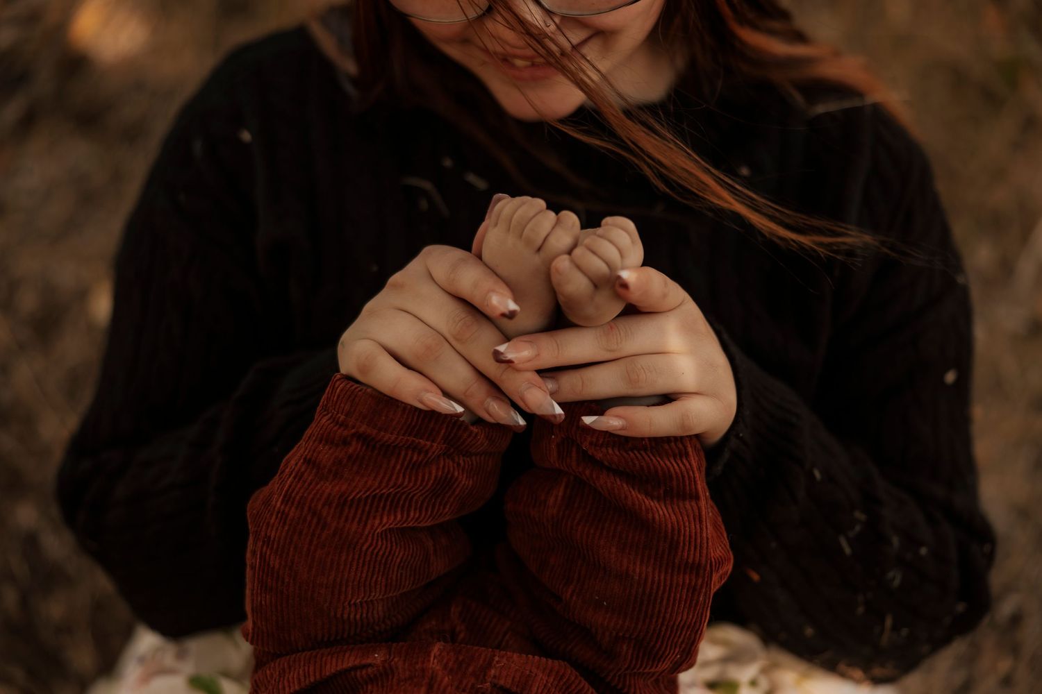 mother holding feet of newborn child