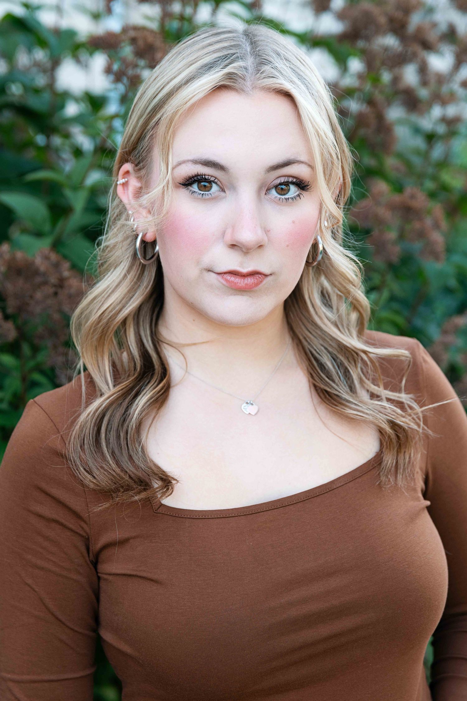 Theatre headshot of blonde woman outside.