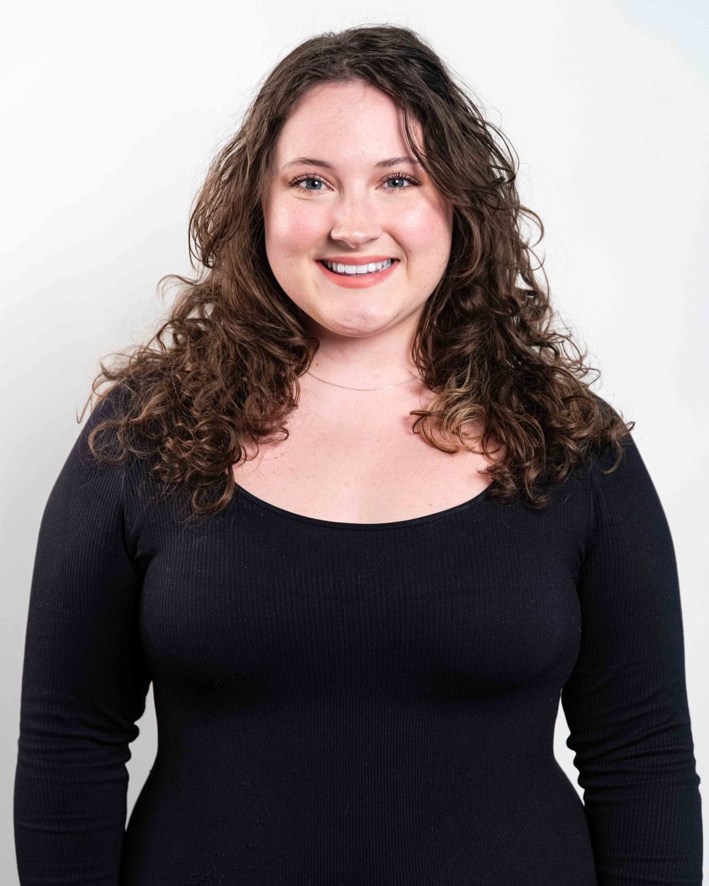 Studio headshot of actor against white backdrop.