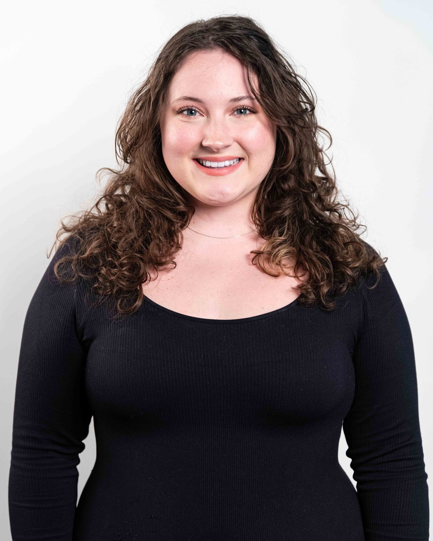 Studio headshot of actor against white backdrop.