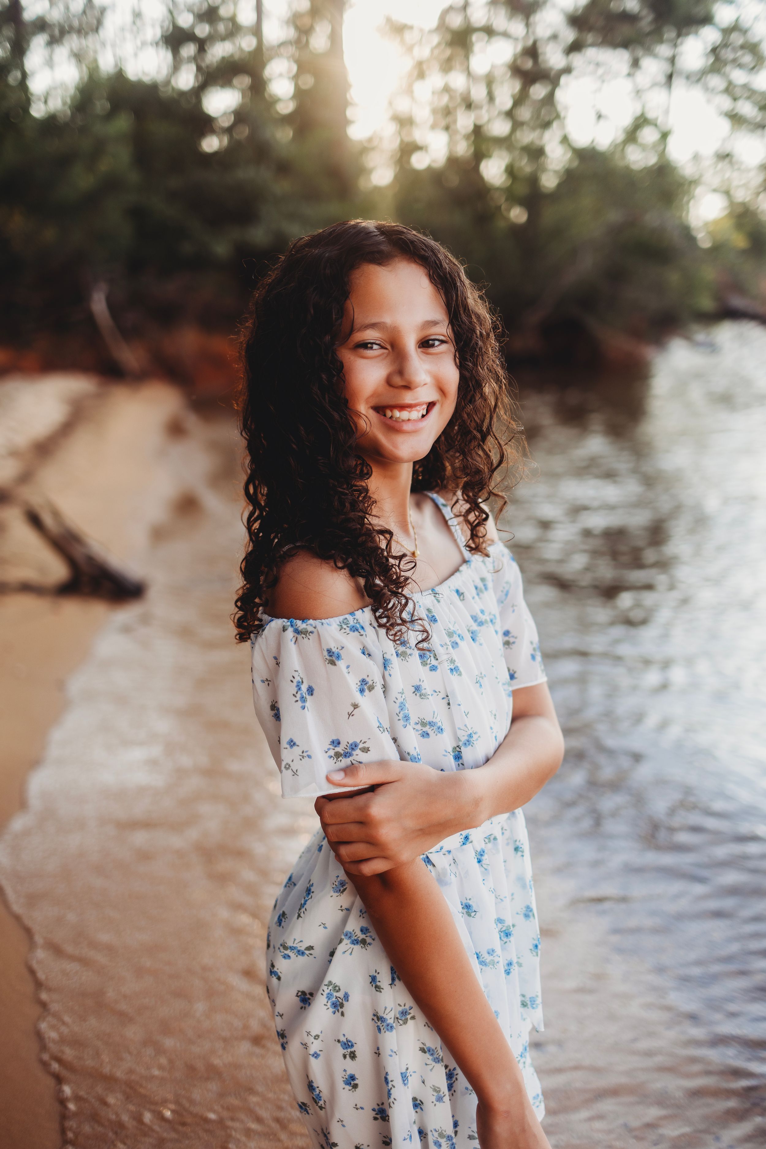 Natural lifestyle portrait by the water with soft sunset lighting.