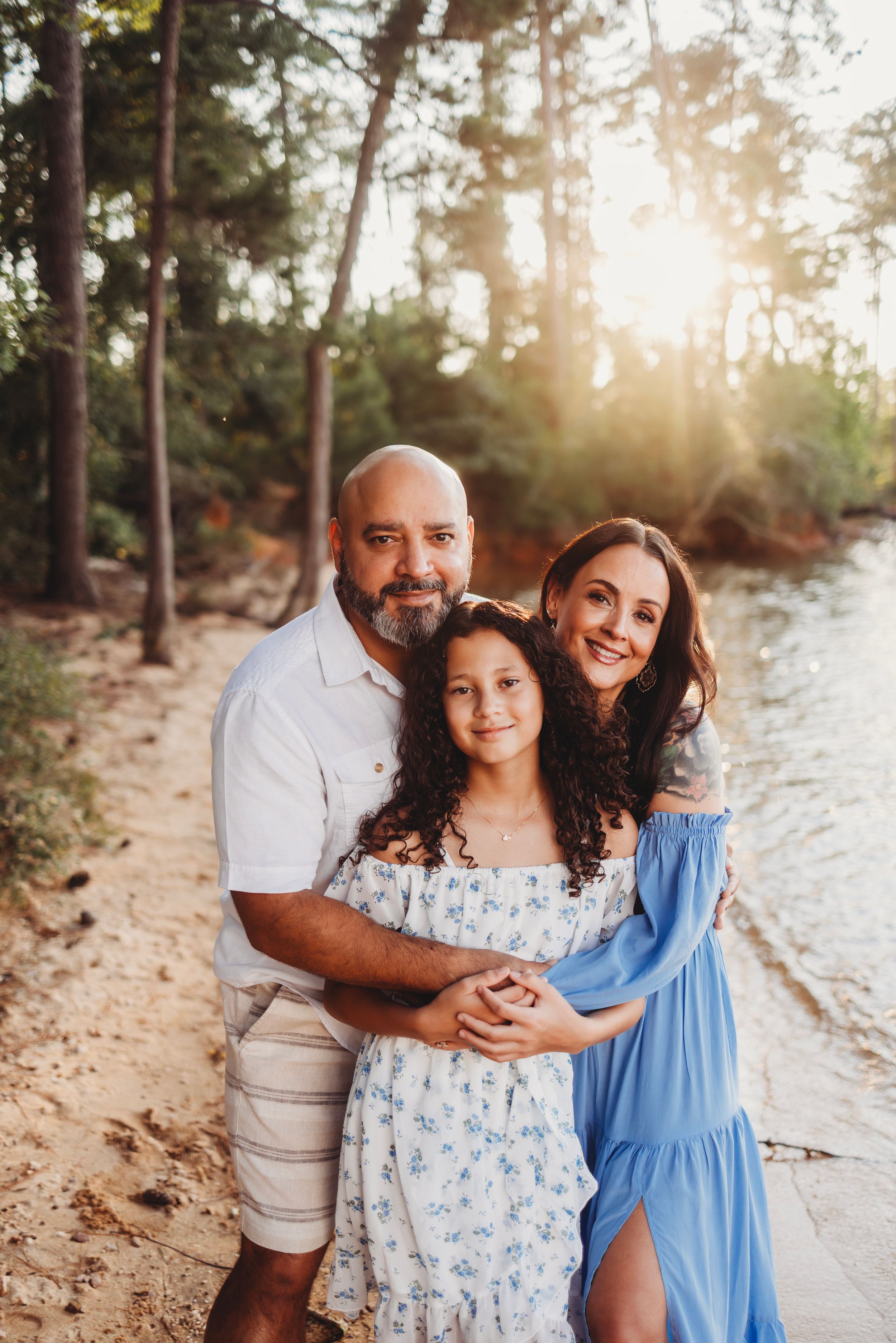 Casual family photo session on sandy beach with sunset glow.
