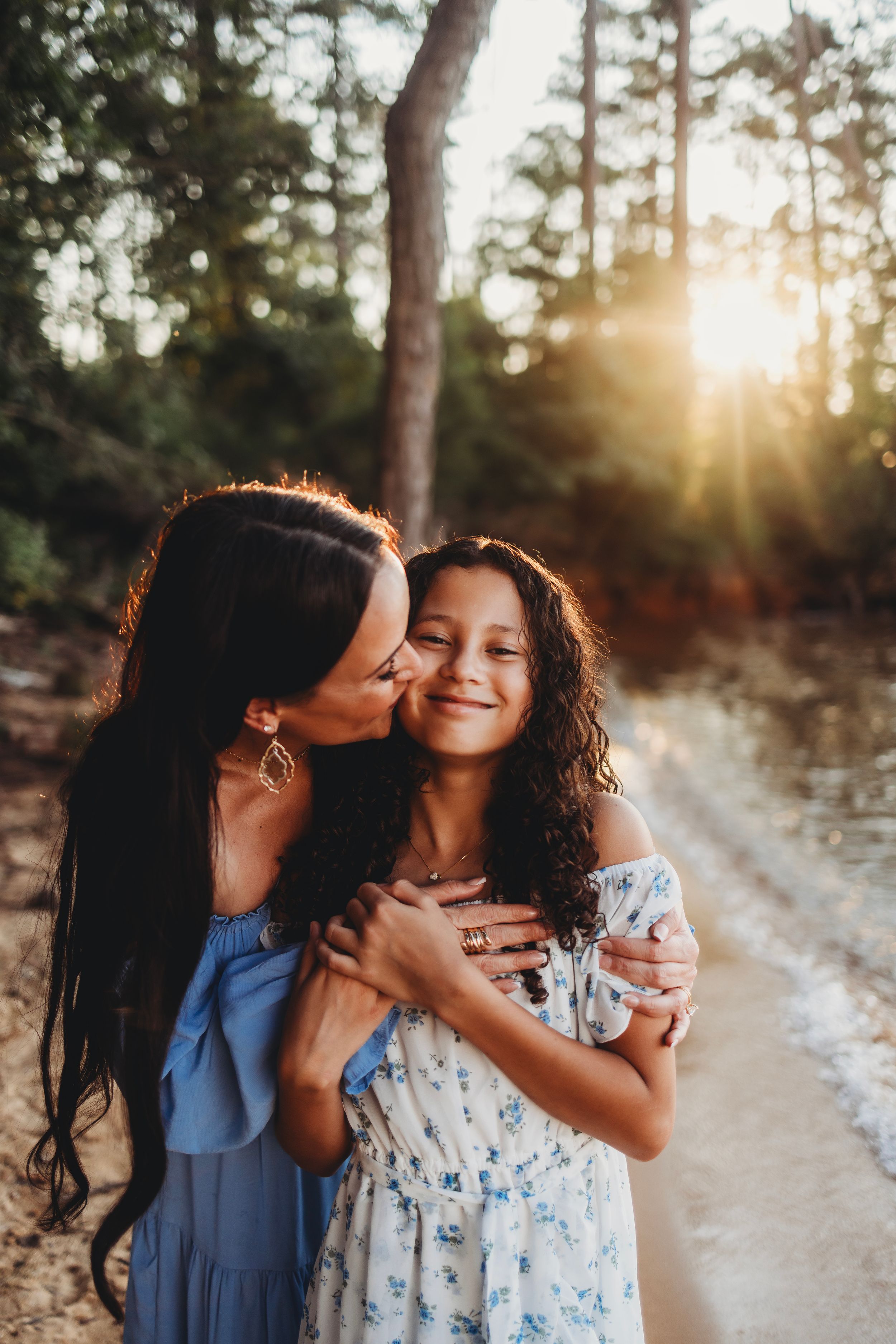 Tender moment between family members captured in warm sunset light.