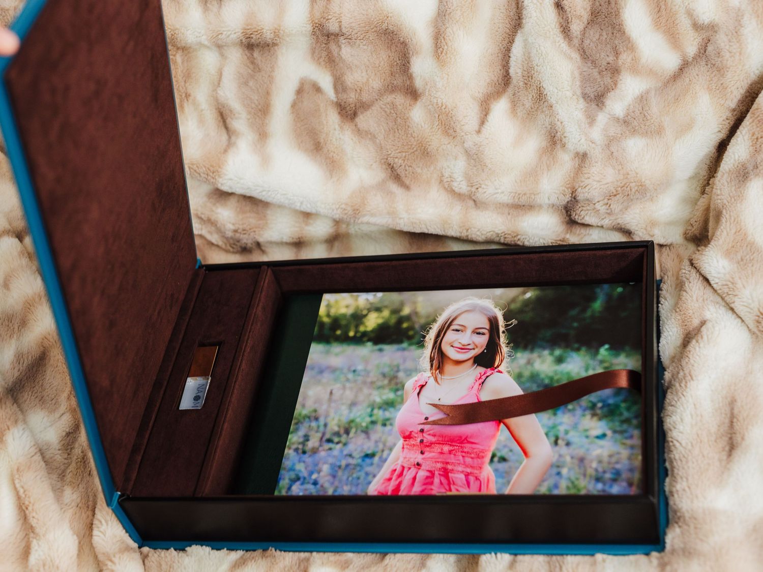 A photo album displaying a portrait of a young subject in a red dress among bluebonnets.