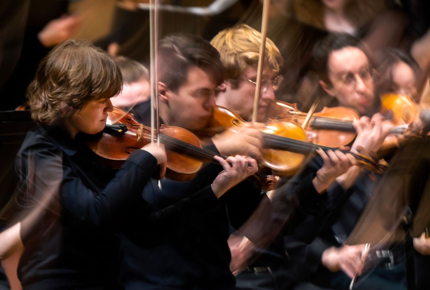 Violinists perform on stage.