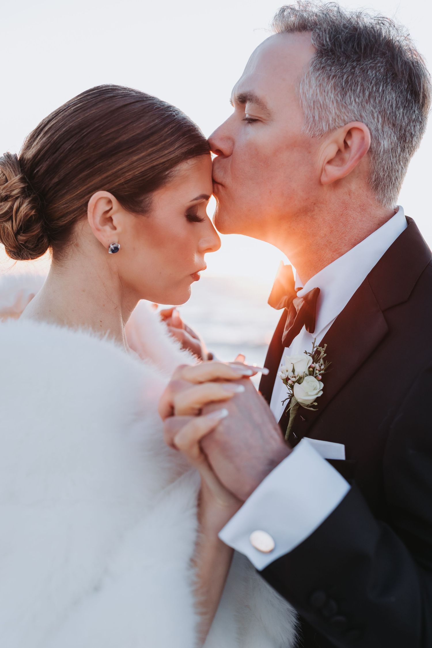 Romantic close-up photos of a bride and groom sharing intimate moments at sunset with soft golden lighting.