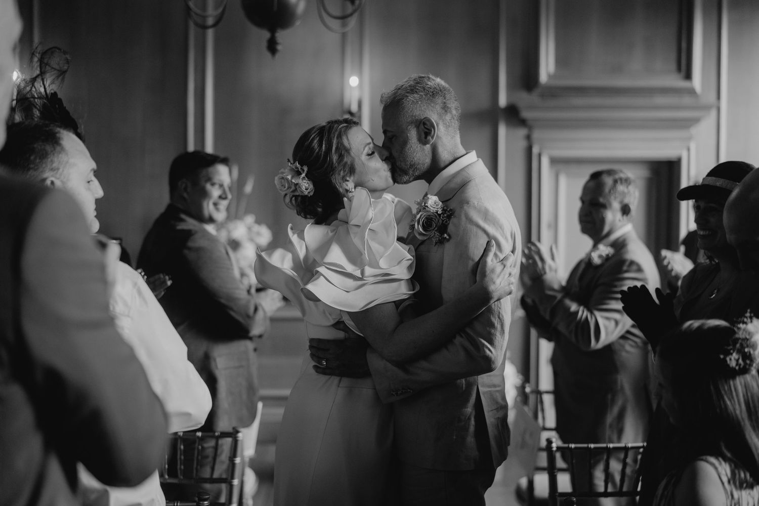 Black and white photo of couples dancing at an intimate indoor reception.