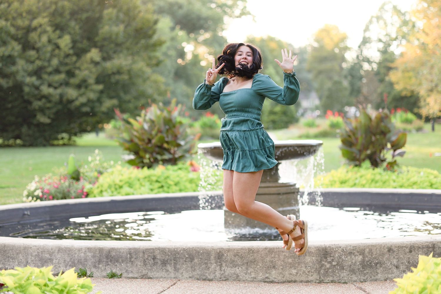 Springfield, IL senior photographer captures a senior jumping in front a fountain at Washington Park Botanical Gardens in Central, IL.