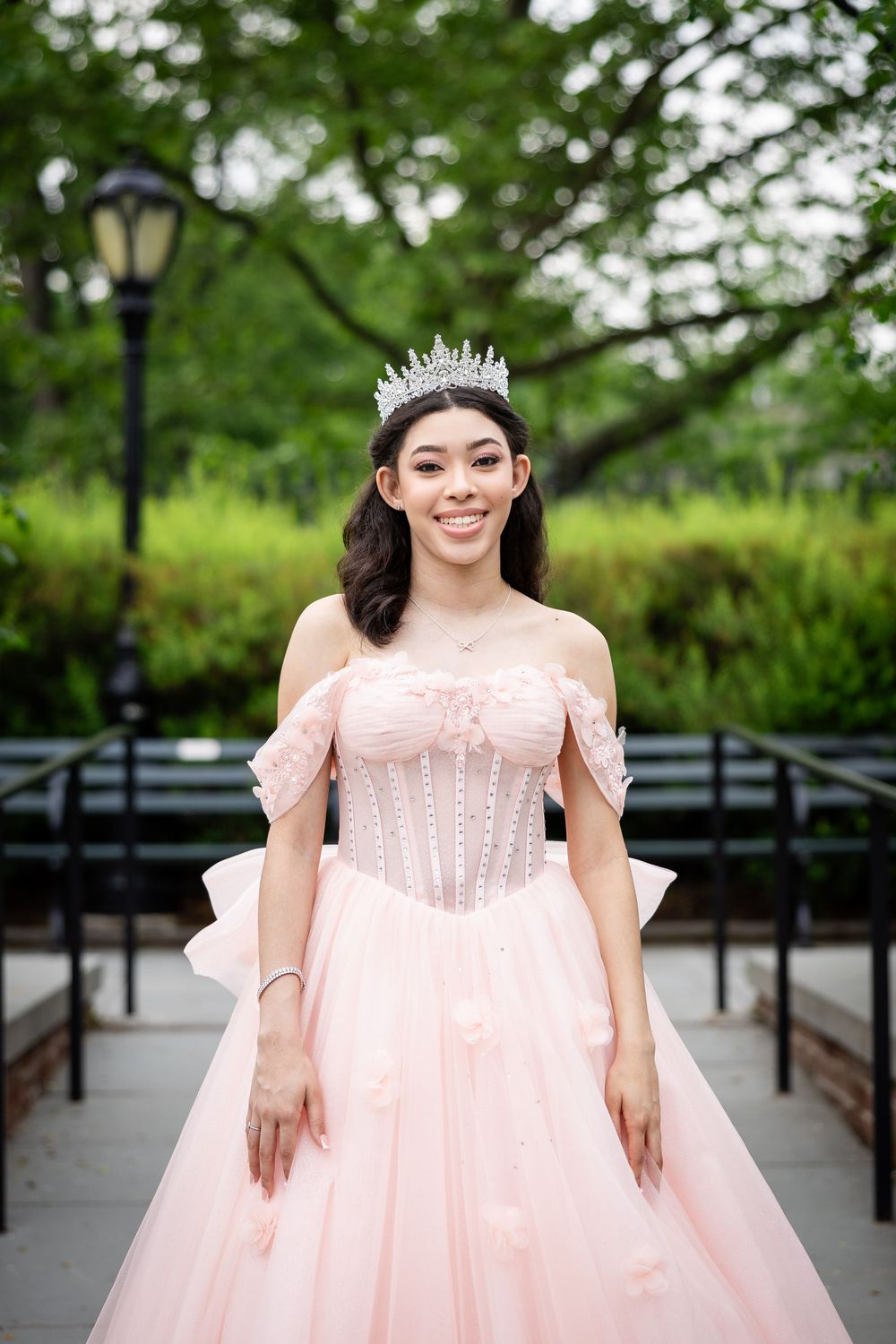 Standing on garden path in pink princess ballgown and crystal crown.