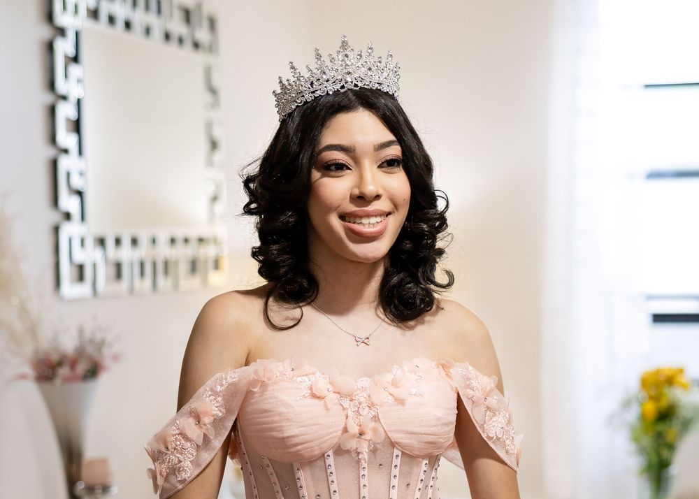 Elegant off-shoulder pink dress with delicate lace details and crystal crown.