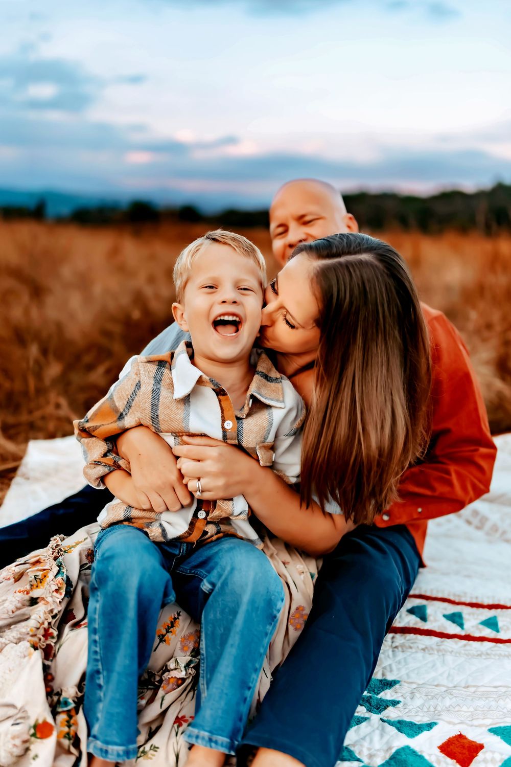 Candid outdoor photo series showing playful interaction between parent and child sitting together on a blanket at sunset.