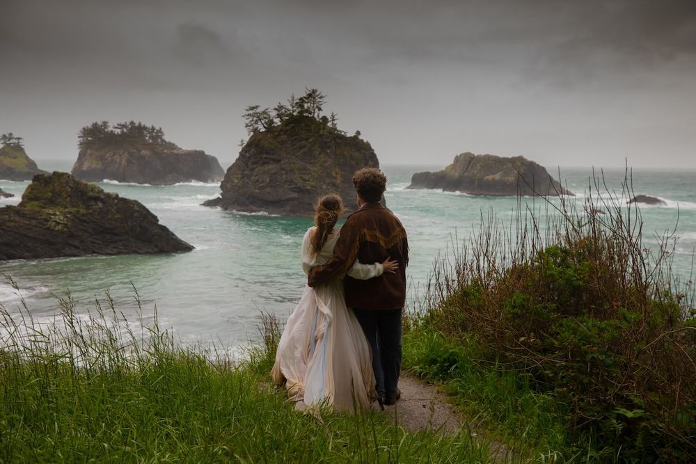 Foggy coastal landscape with dramatic cliffs and rocky shores along a moody coastline.