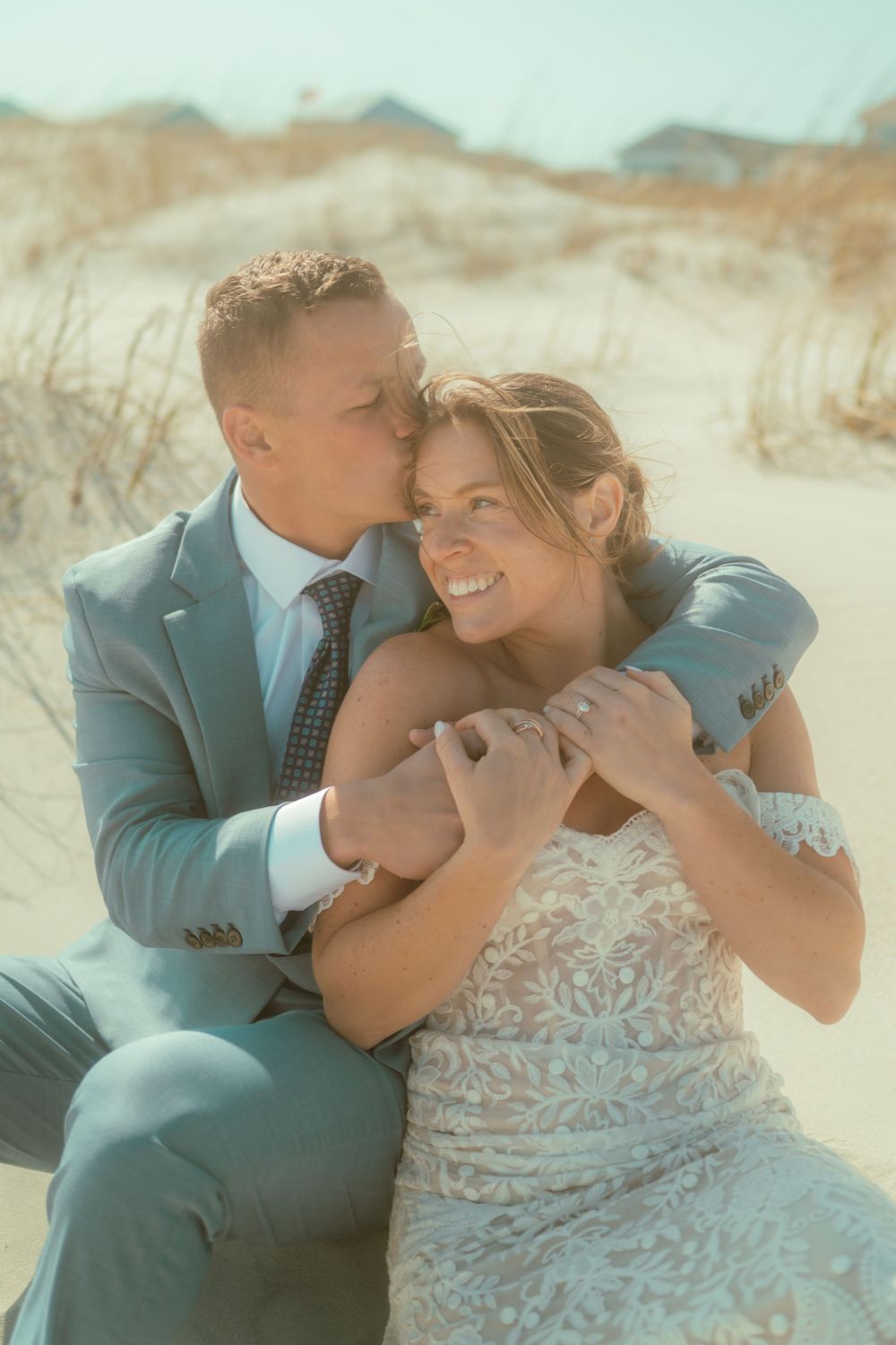 A romantic sandy dunes wedding portrait with soft lighting.