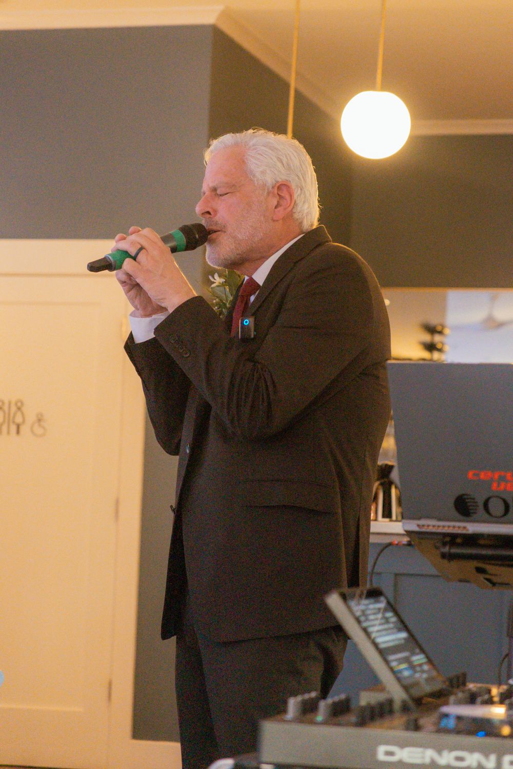 An elegantly dressed performer sings into a microphone at the wedding reception.