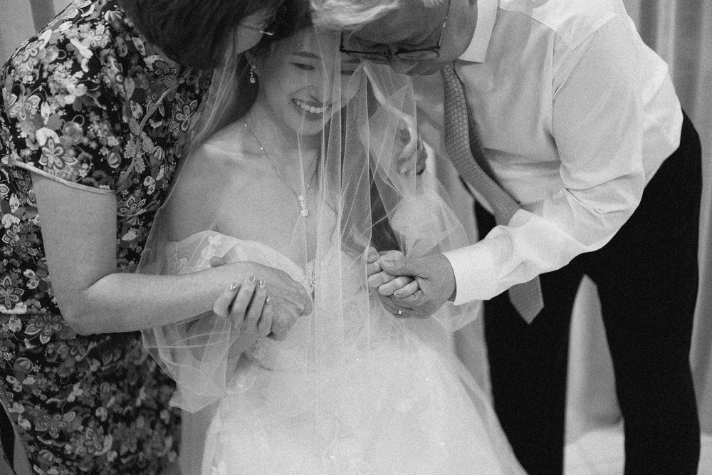 A series of romantic black and white wedding photos showing sweet candid moments between a couple during their celebration.