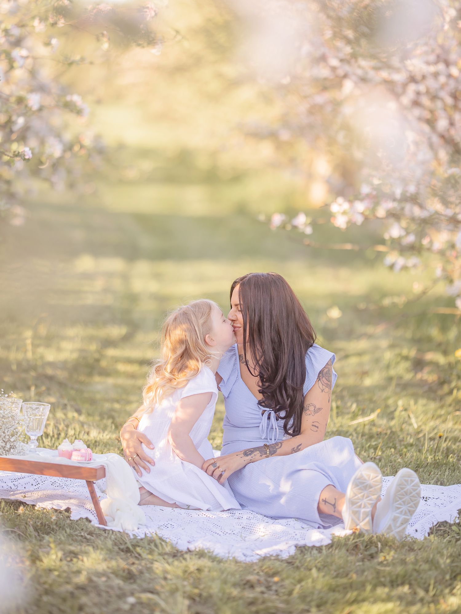 Mamma och barn vid blommande träd i kvällsljus, familjefotografering Västerås. MemoriebyM