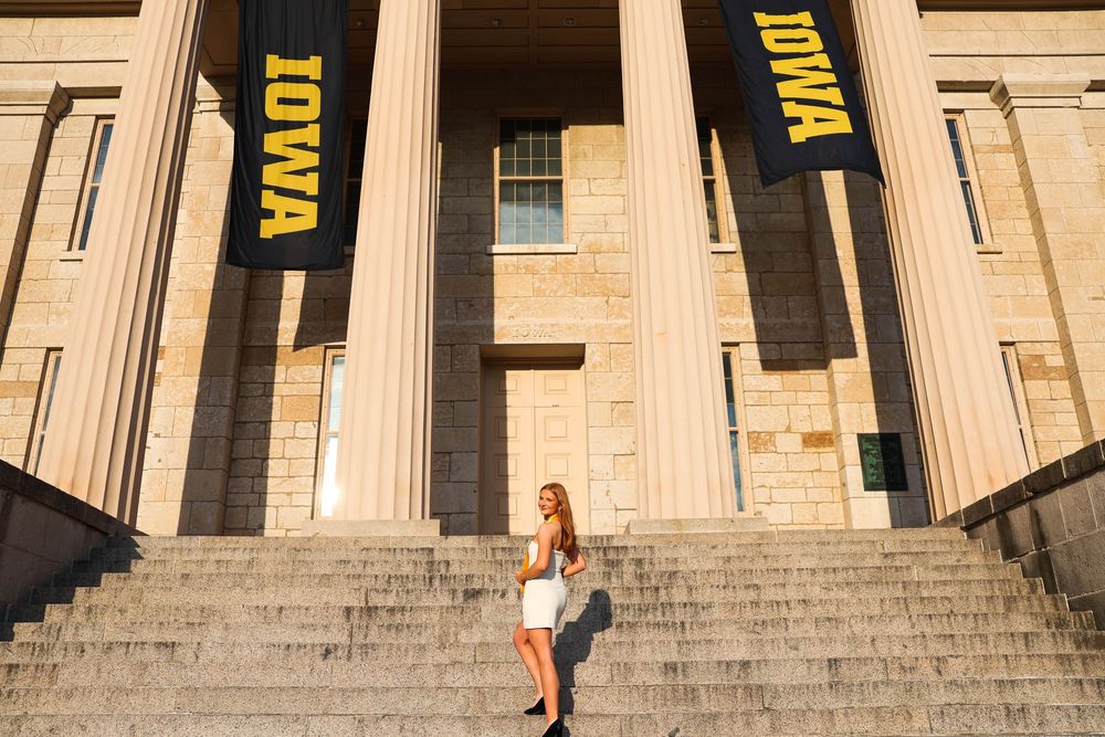 Stone columns and black banners with IOWA text displayed across the historic university building facade.