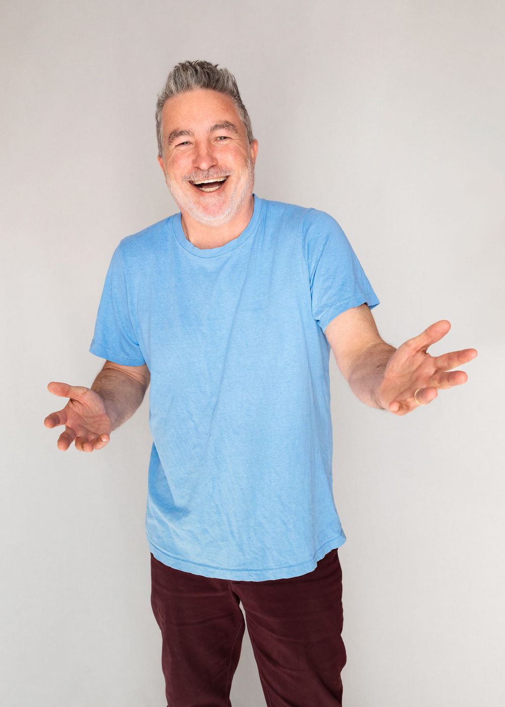 New Zealand famous comedian Dai Henwood laughing with his hands in the air in photo studio