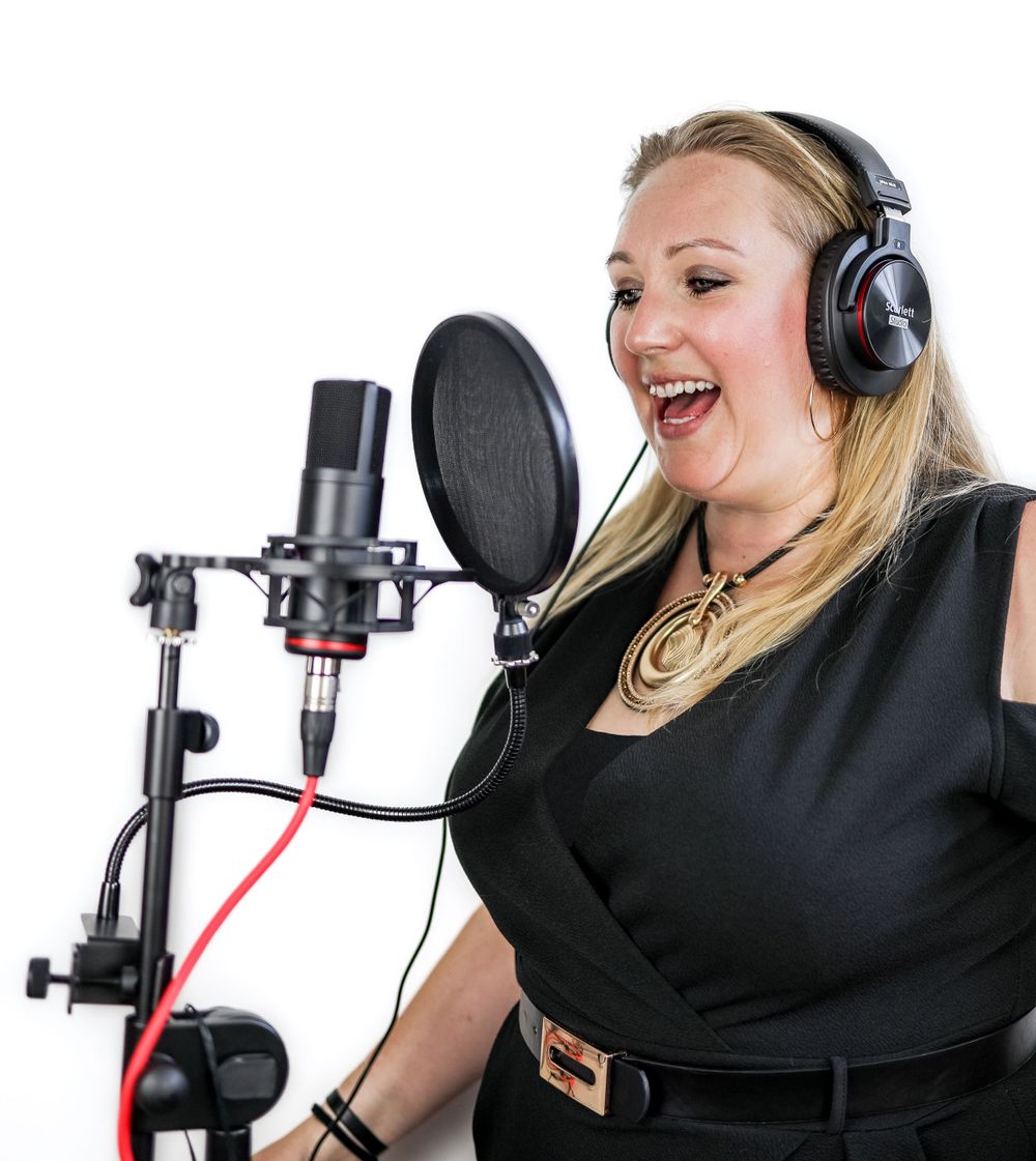 Professional portrait of female Voice over Artist wearing headphones talking into microphone