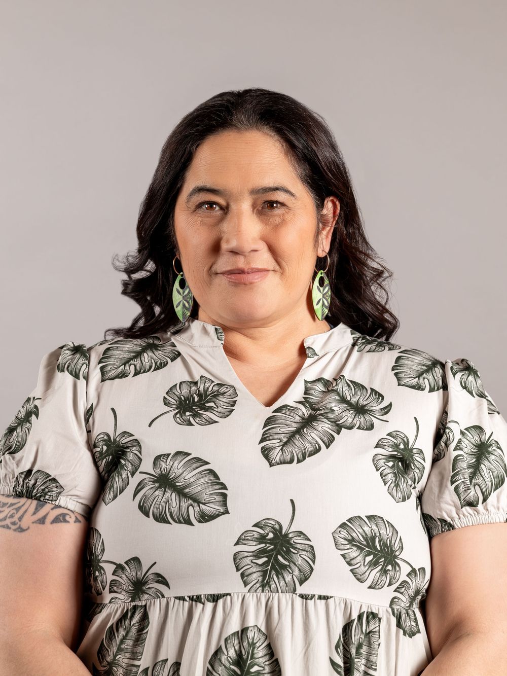 Professional headshot. Auckland. Pacific Island woman wearing a beautiful dress with leaf print. Long green dangly earrings. CL Photography