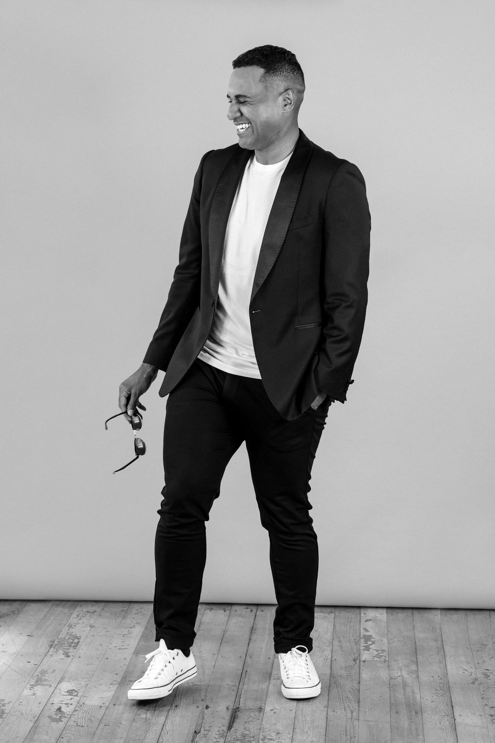Black and white professional portrait of man holding sunglasses for a smart casual branding photoshoot