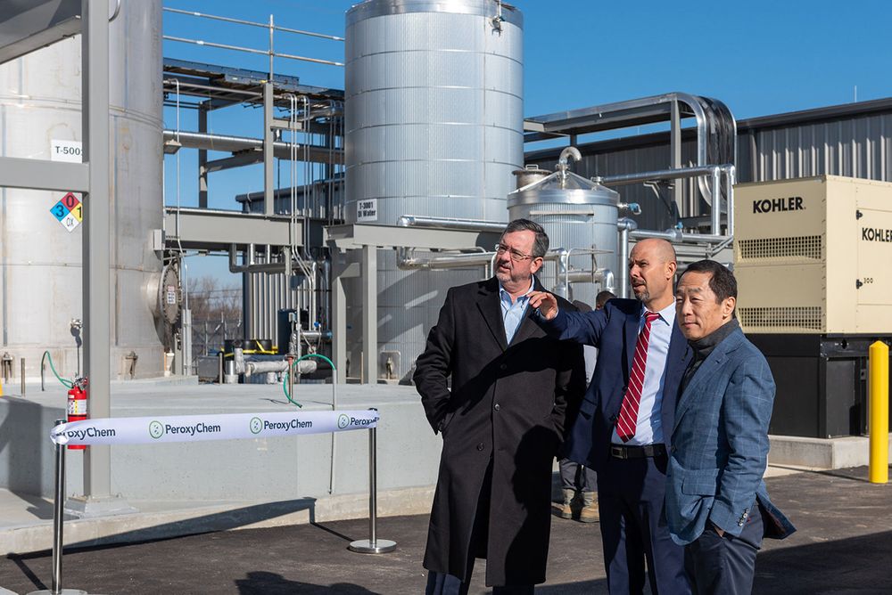 Industrial chemical processing facility with storage tanks and equipment bearing PeroxyChem branding.