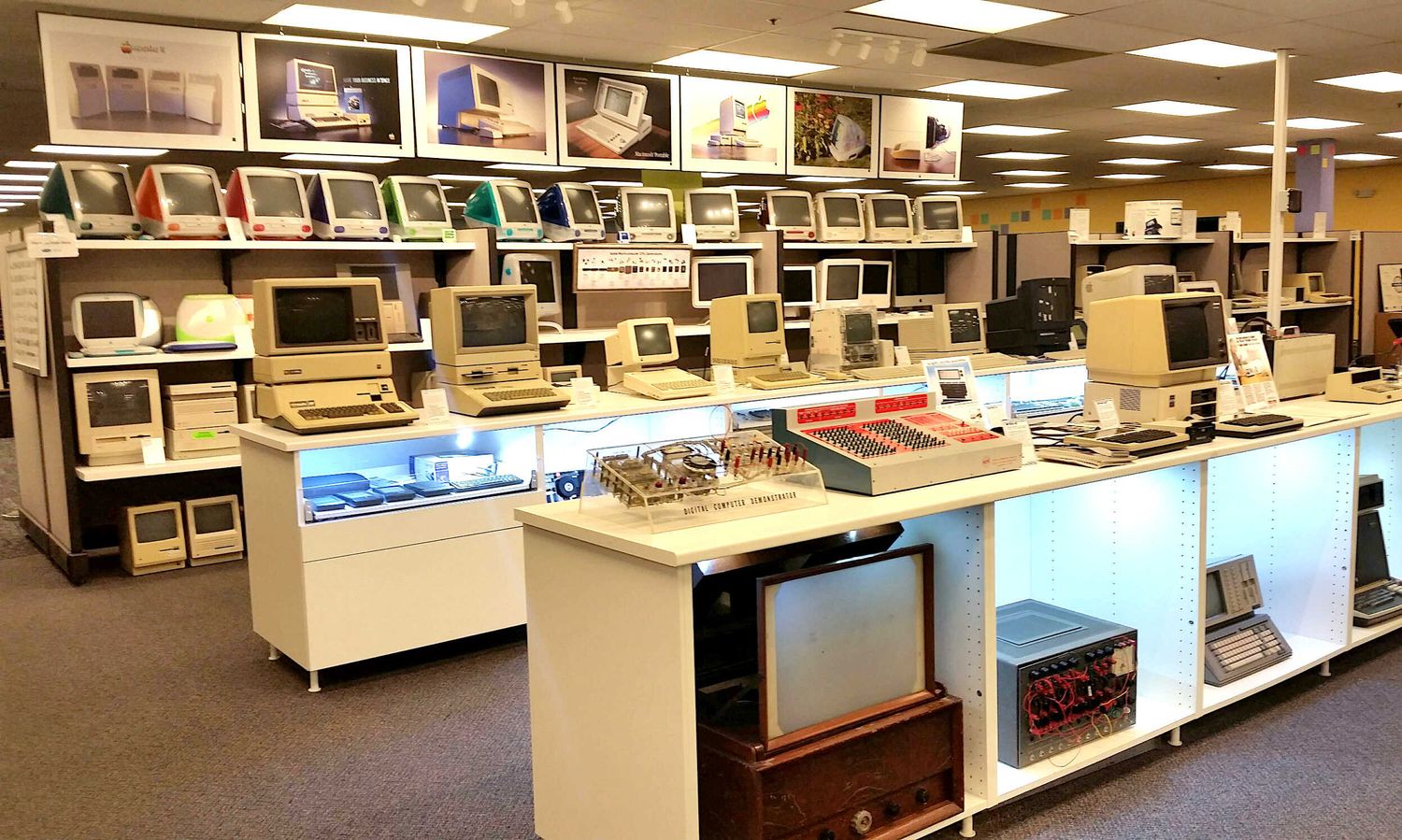 Vintage computer lab with rows of classic monitors and beige PCs displayed in a retail or museum setting.