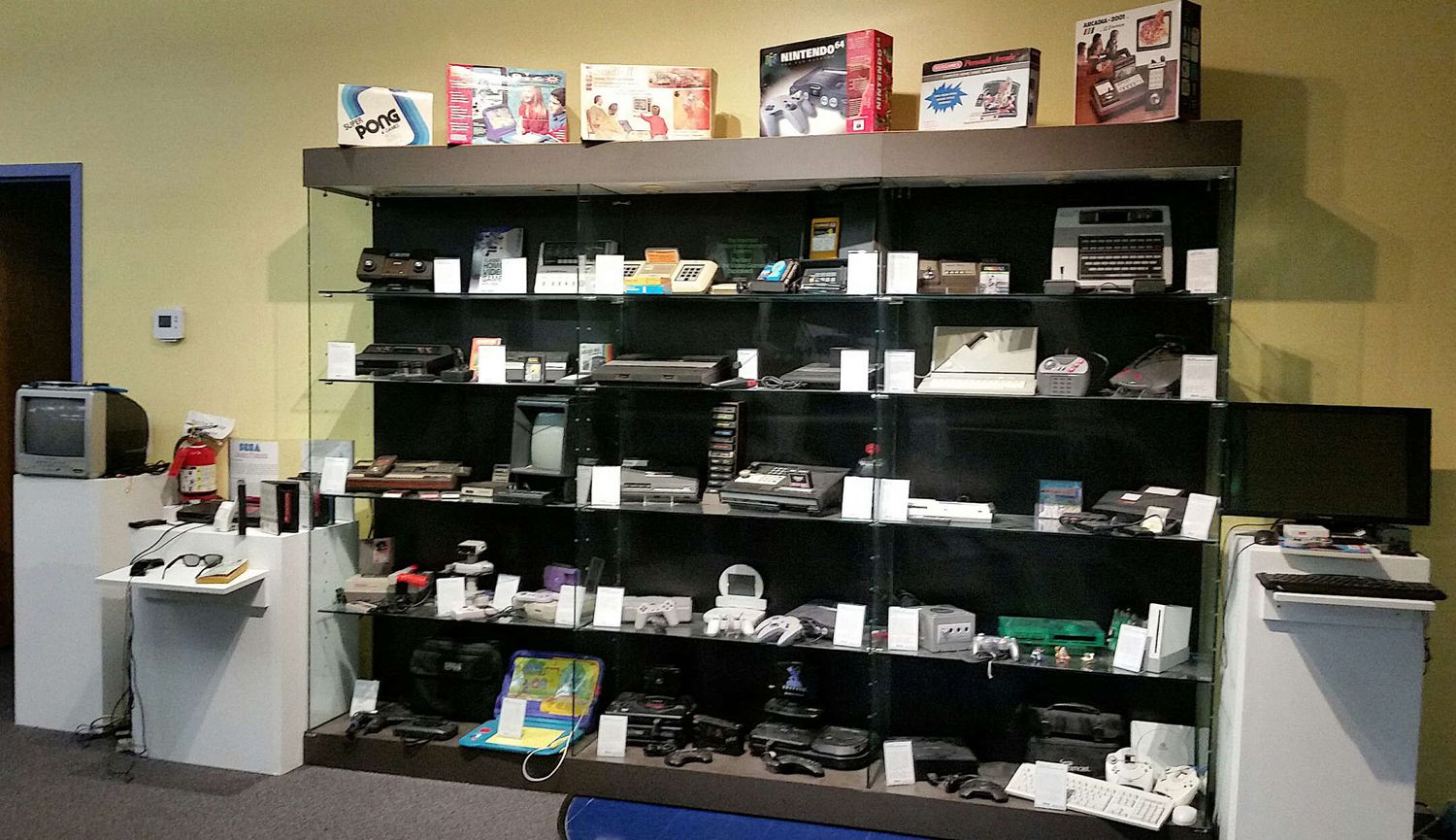 Retail store displays featuring multiple shelves of electronic devices and accessories arranged in rows.