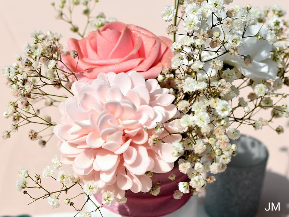 Soft pink roses and white baby's breath flowers arranged in an elegant display.