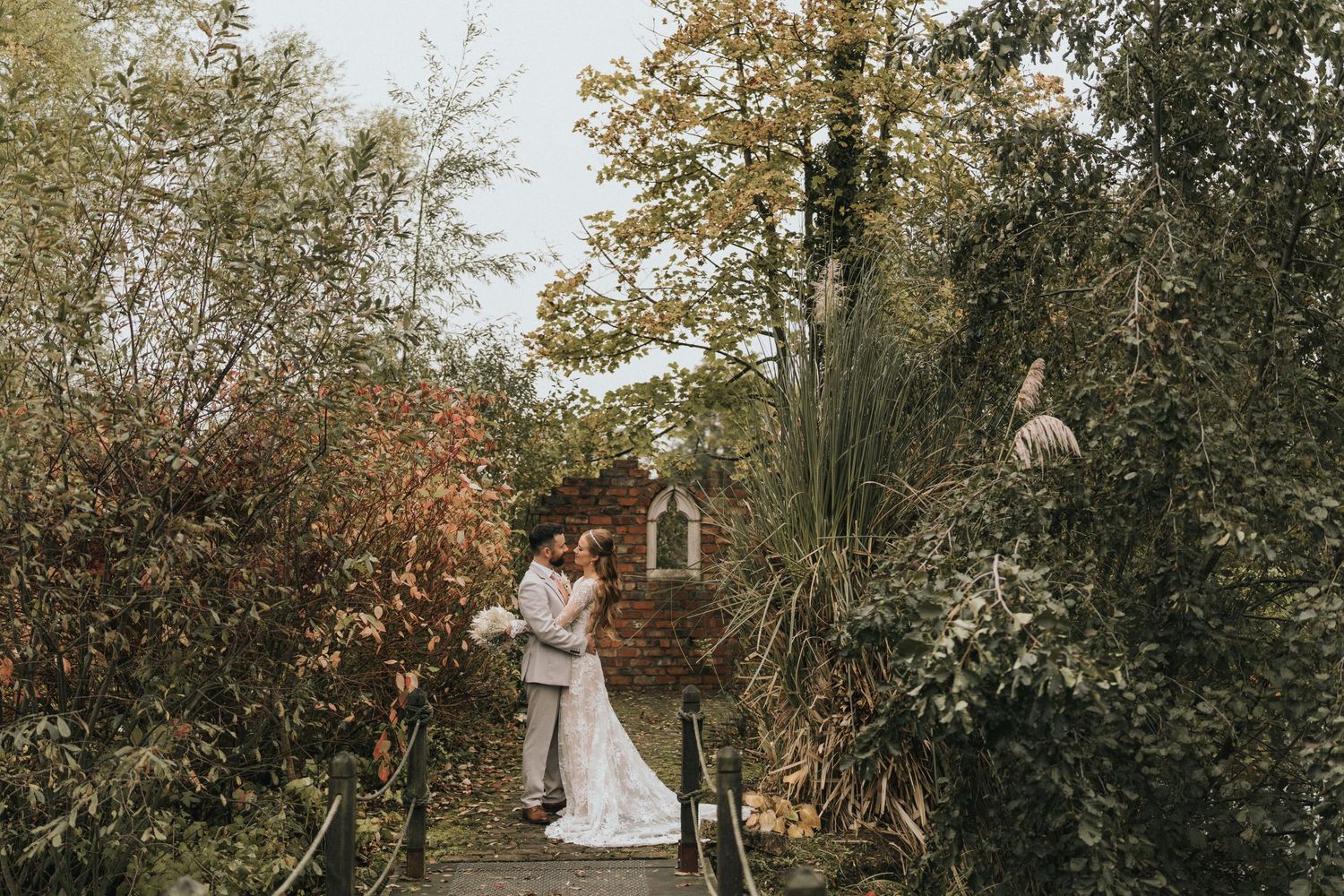 A couple poses together on their wedding day in front of Laceby Manor - image captured by Grimsby photographers.
