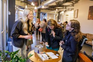 CEO Society women's networking event in Mercer Island, WA women at entry writing down names on tags and laughing together connecting