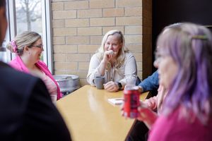 Eastside Entrepreneurs women business owner networking group in Redmond, WA sitting at table learning, taking notes, connecting, Laughing