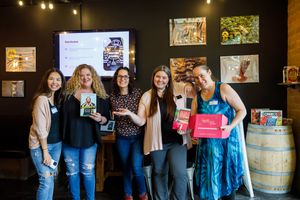 Eastside Entrepreneurs women business owner networking group in Redmond, WA  group standing together holding swag box