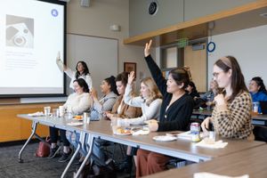 CEO Society women's networking event in Mercer Island, WA women raising hands to agree with question of presentation to learn together