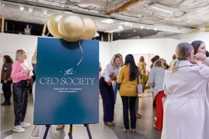 CEO Society women's networking event in Mercer Island, WA display signage of event with groups of women standing in background connecting
