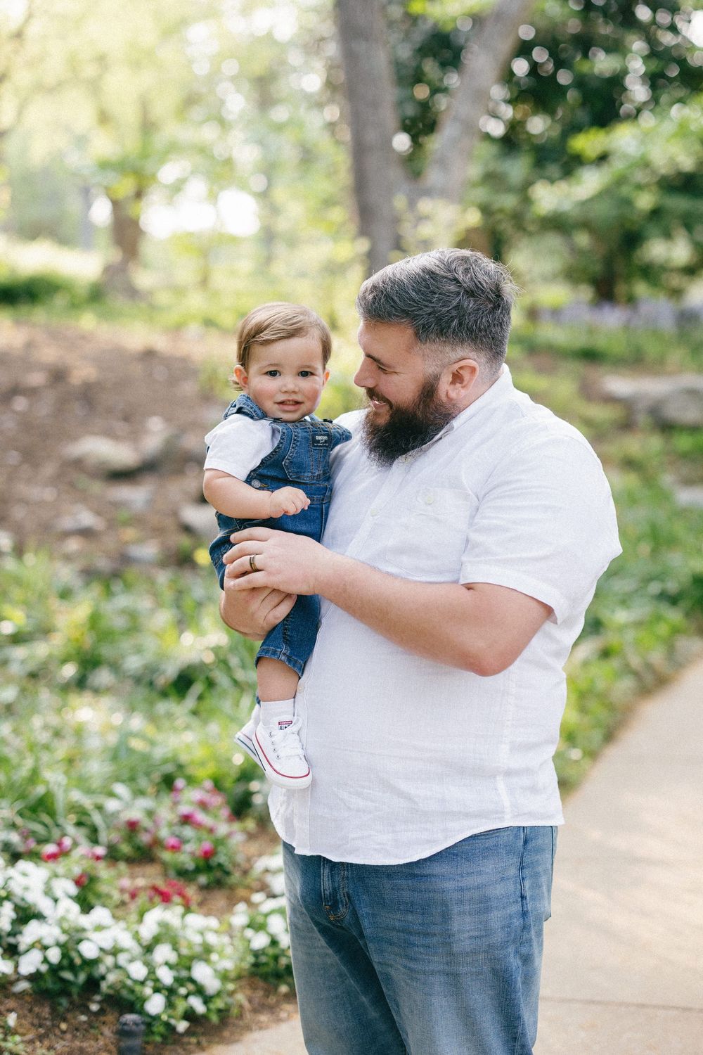 A heartwarming family interaction set against a lush garden backdrop with soft natural lighting.