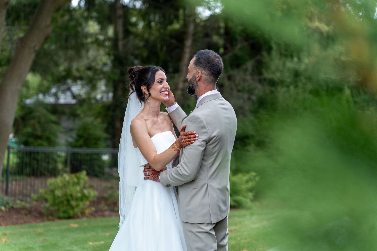 Bride and groom share intimate outdoor wedding moments in a lush garden setting with natural greenery.