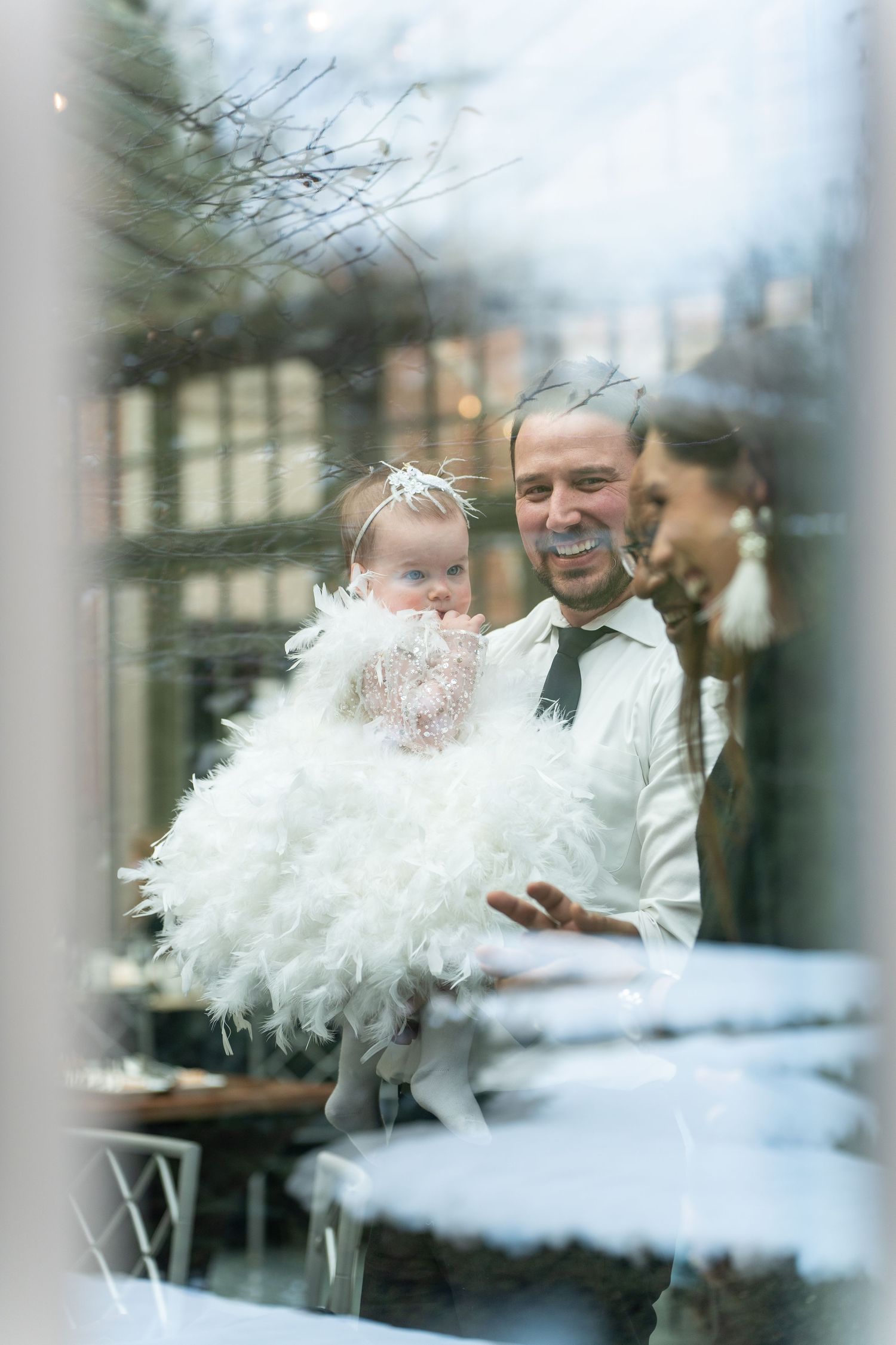 White rose bouquets reflected in glass windows create a dreamy, ethereal wedding scene.