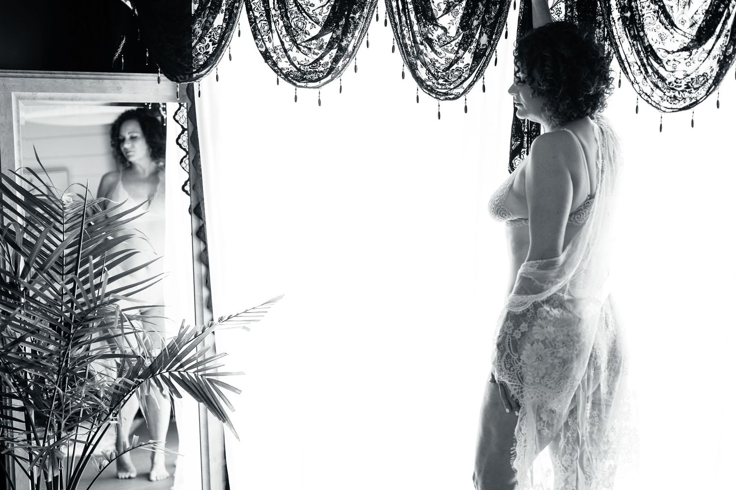 Romantic boudoir photography with twinkling lights and lace lingerie details.