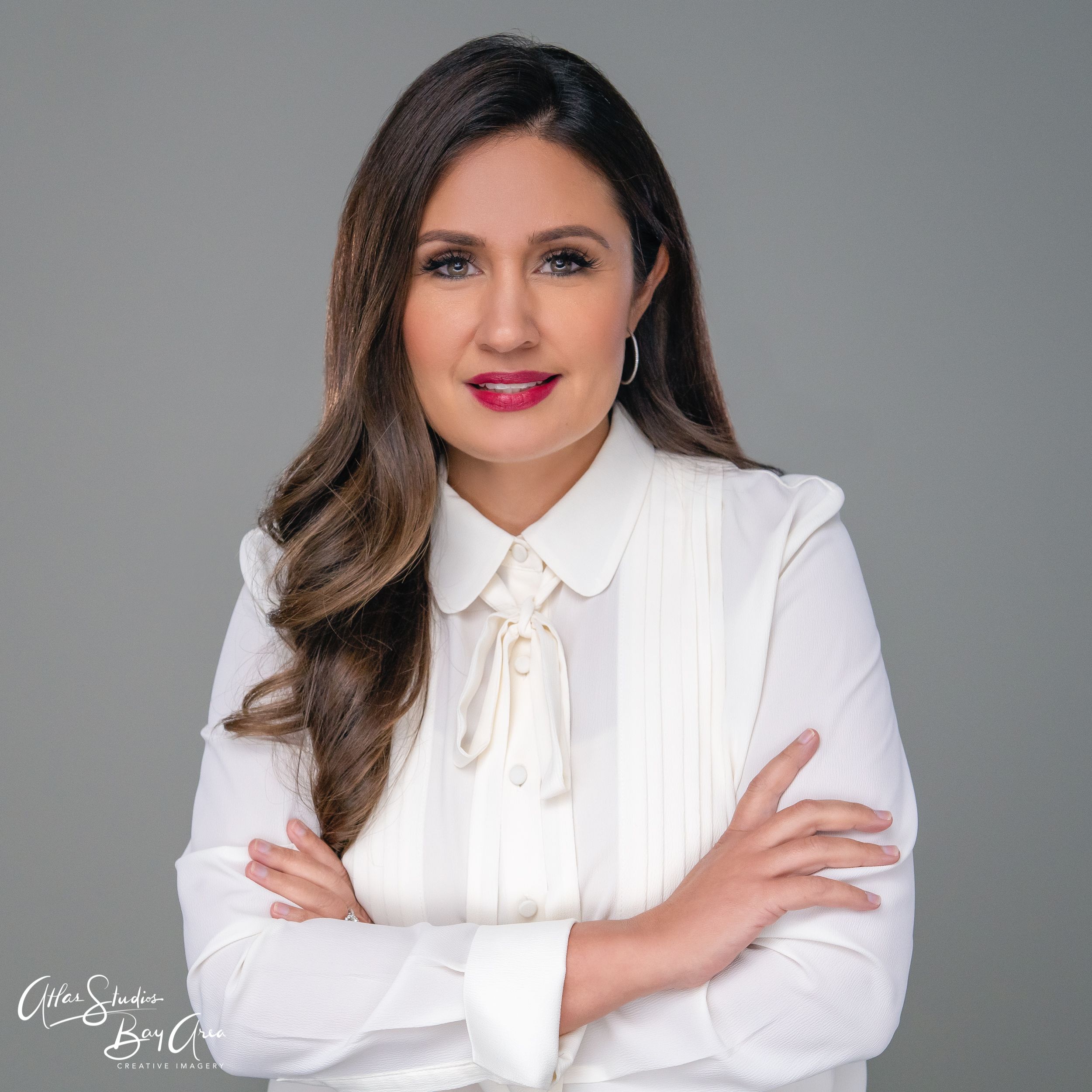Professional headshot series showing a person in a white blouse posing against a gray background in different poses.
