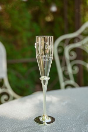 Row of elegant champagne flutes on display, showing delicate glassware against a blurred natural background.