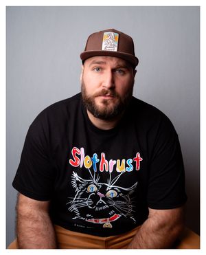 Self portrait wearing a black Slothrust "I like cats, do you like cats?" t-shirt.